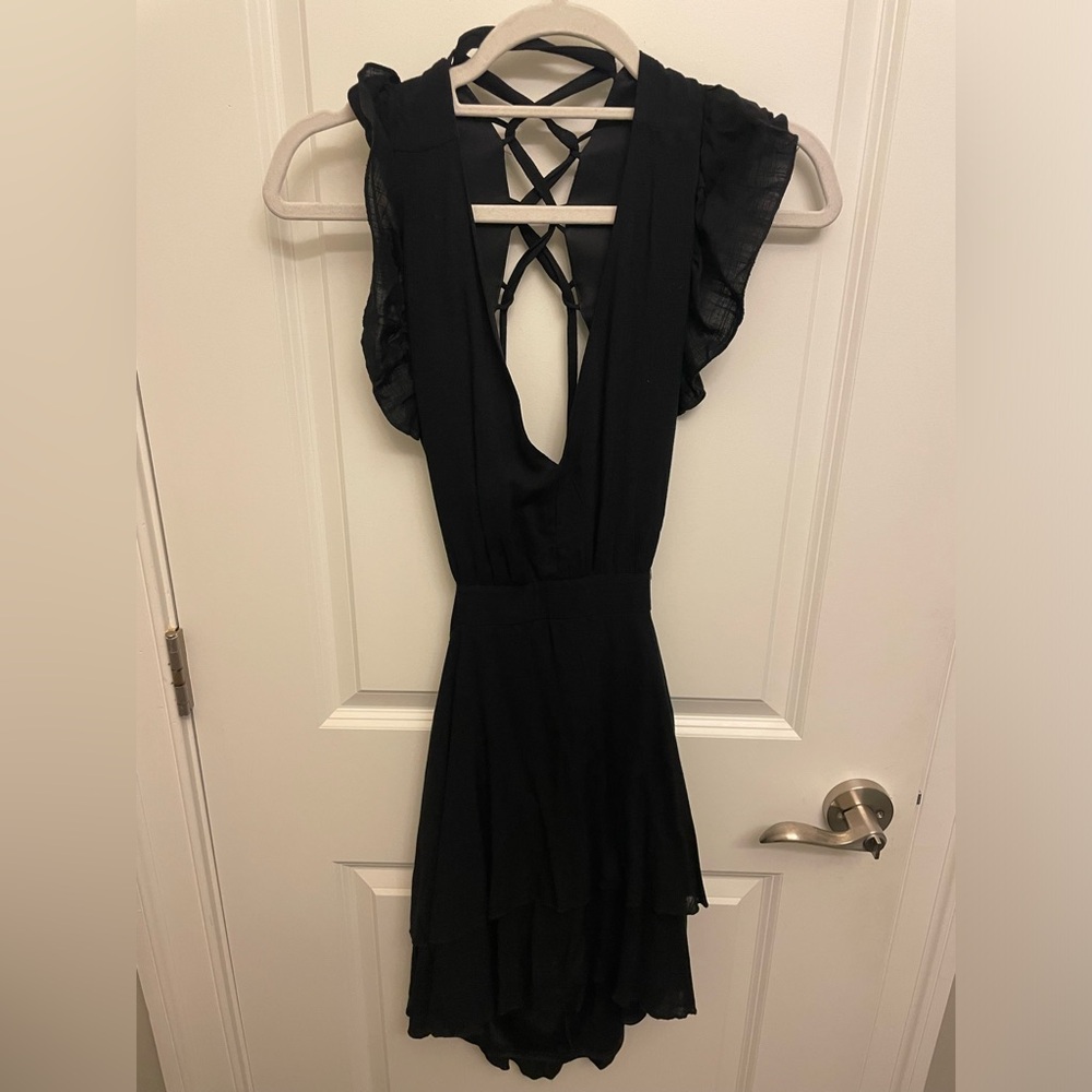 Black v-neck dress with an open back and straps.